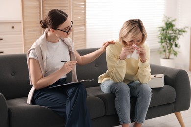 Professional psychotherapist working with on sofa patient in office