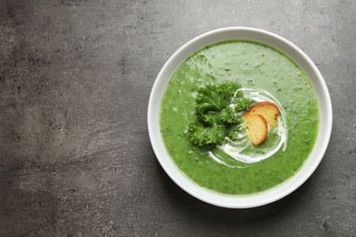Photo of Tasty kale soup on grey table, top view. Space for text