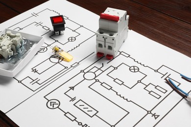 Photo of Wiring diagrams and different electrician's equipment on wooden table