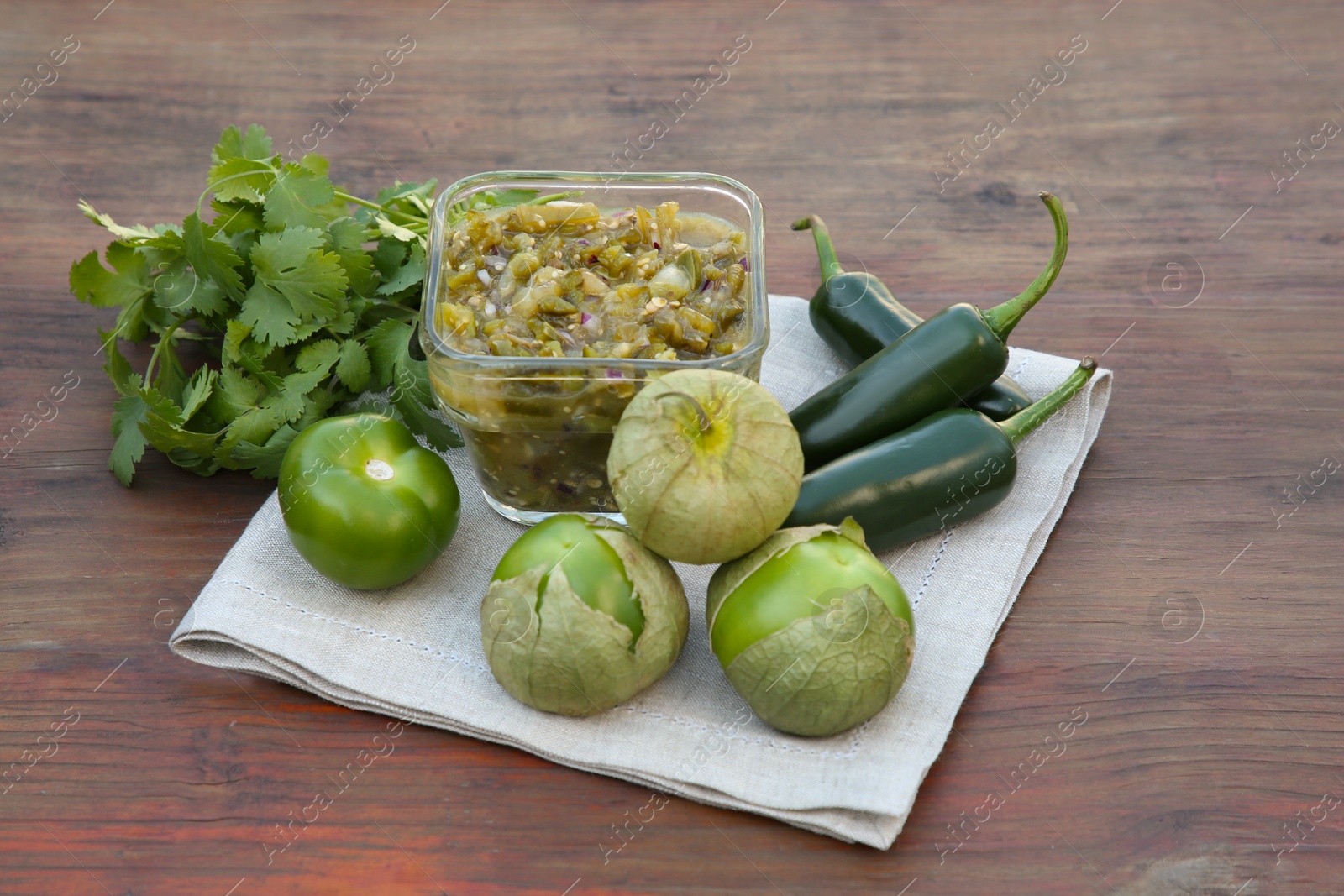 Photo of Tasty salsa sauce and ingredients on wooden table