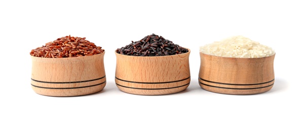 Photo of Bowls with different types of uncooked rice on white background