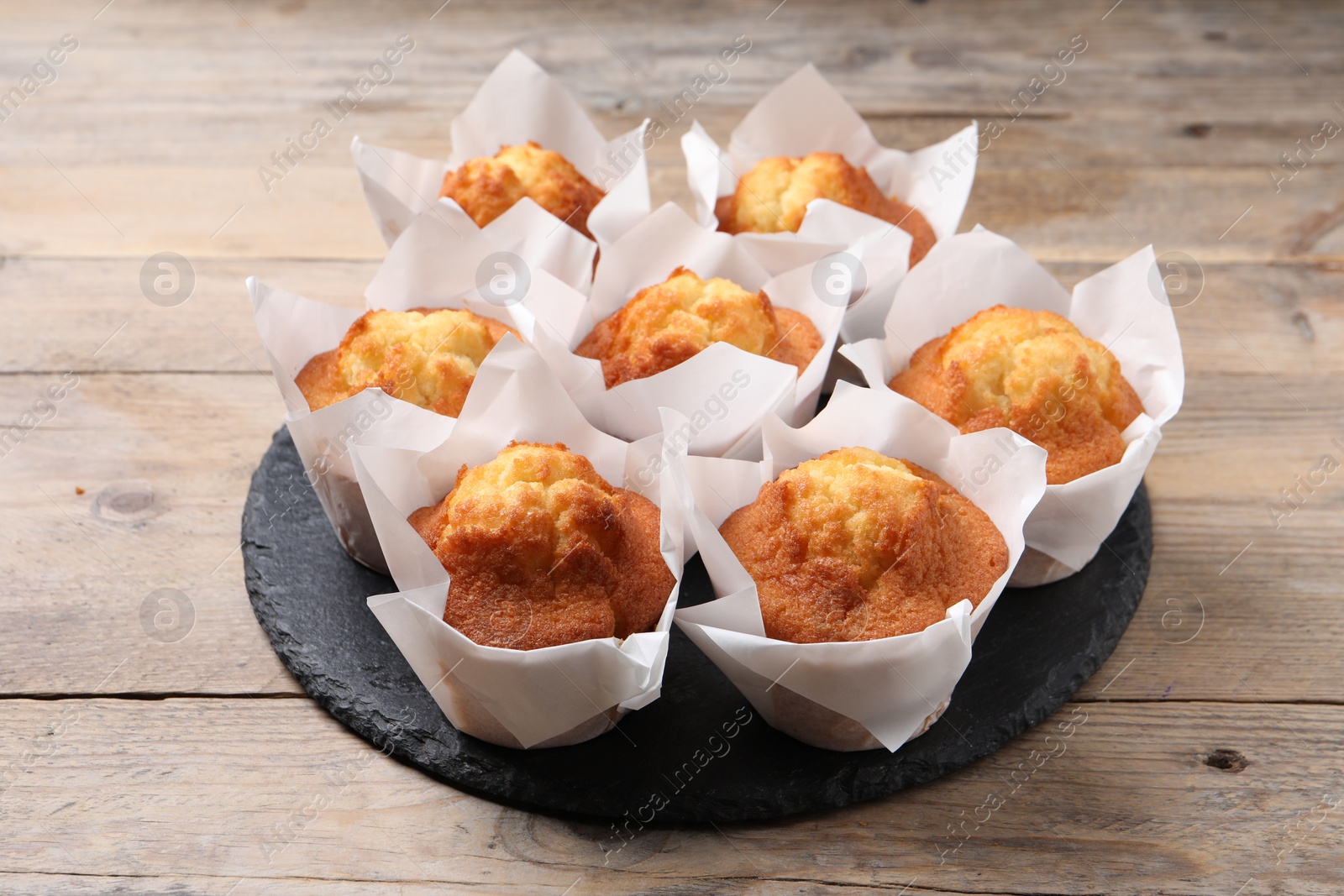 Photo of Delicious sweet muffins on wooden table, closeup