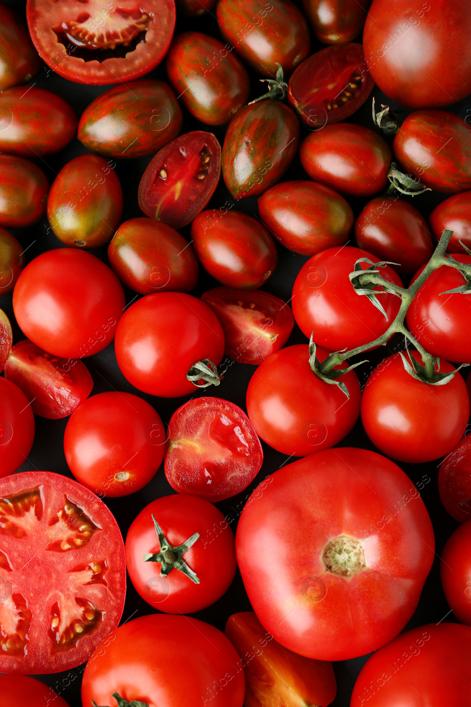 Photo of Many fresh ripe whole and cut tomatoes as background, top view