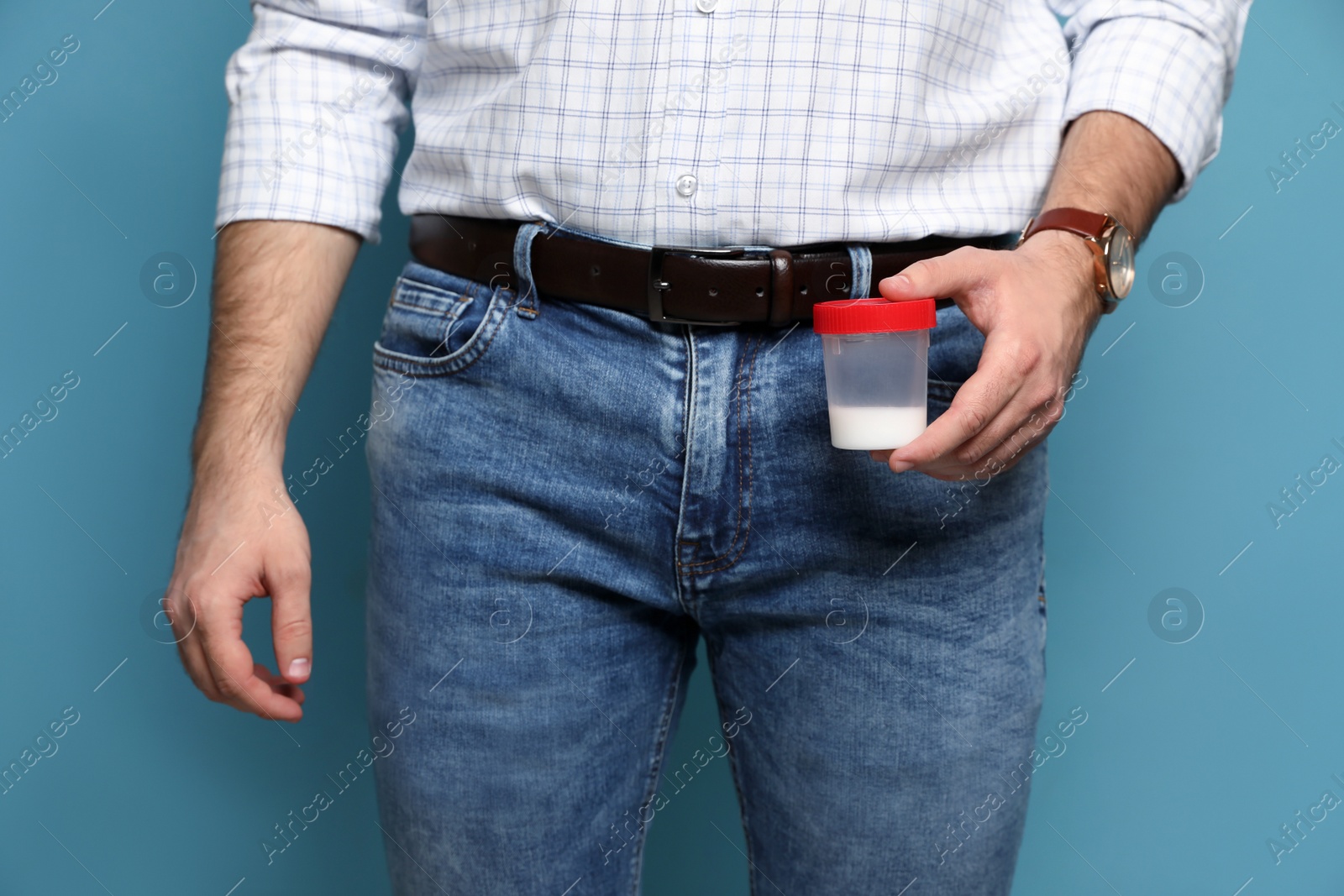 Photo of Donor holding container with sperm on turquoise background, closeup