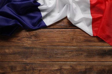 Photo of Flag of France on wooden background, top view. Space for text