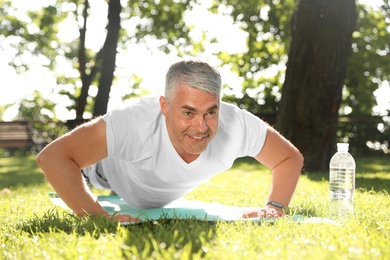 Handsome mature man doing exercise in park. Healthy lifestyle