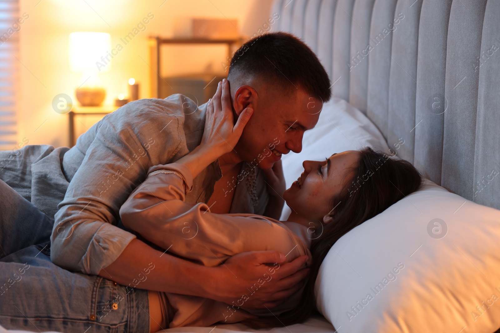 Photo of Affectionate couple enjoying each other on bed at night