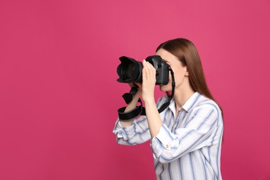 Professional photographer taking picture on pink background