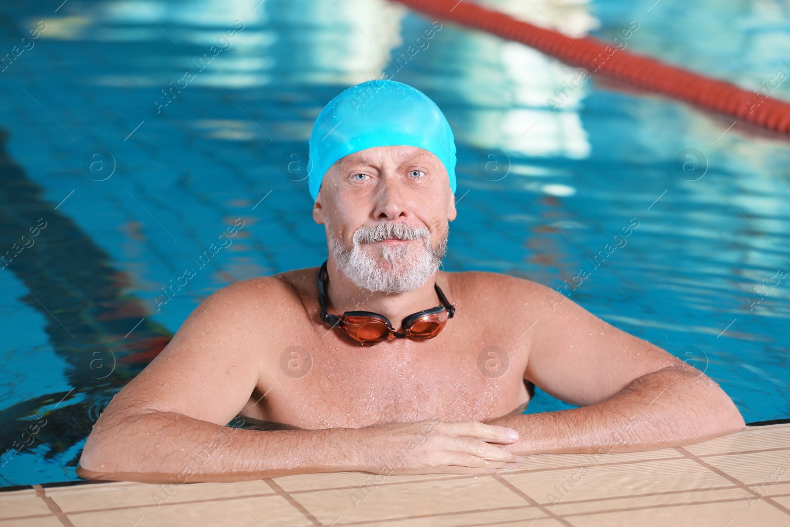 Photo of Sportive senior man in indoor swimming pool