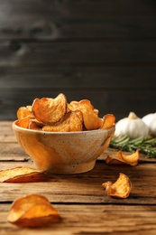 Photo of Delicious sweet potato chips in bowl on table