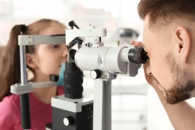 Photo of Ophthalmologist examining little girl in clinic