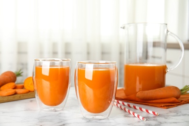 Photo of Freshly made carrot juice on white marble table