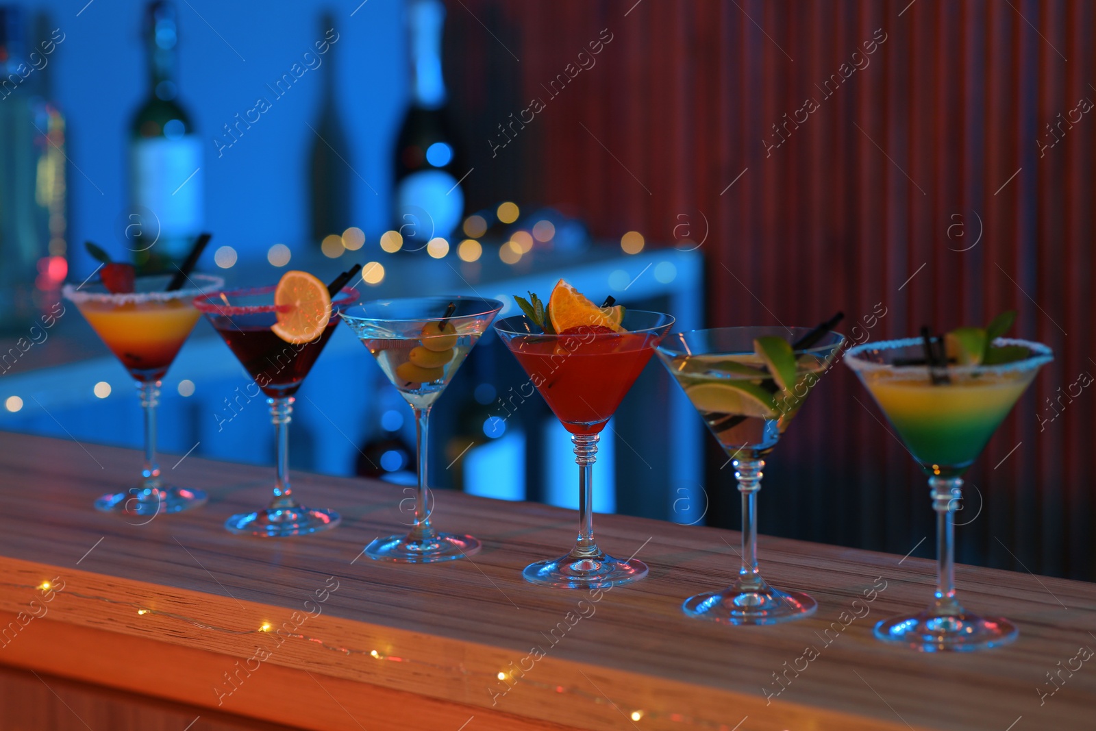 Photo of Different martini cocktails on table in bar