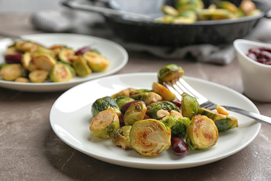 Photo of Delicious roasted brussels sprouts with red beans and peanuts served on grey marble table