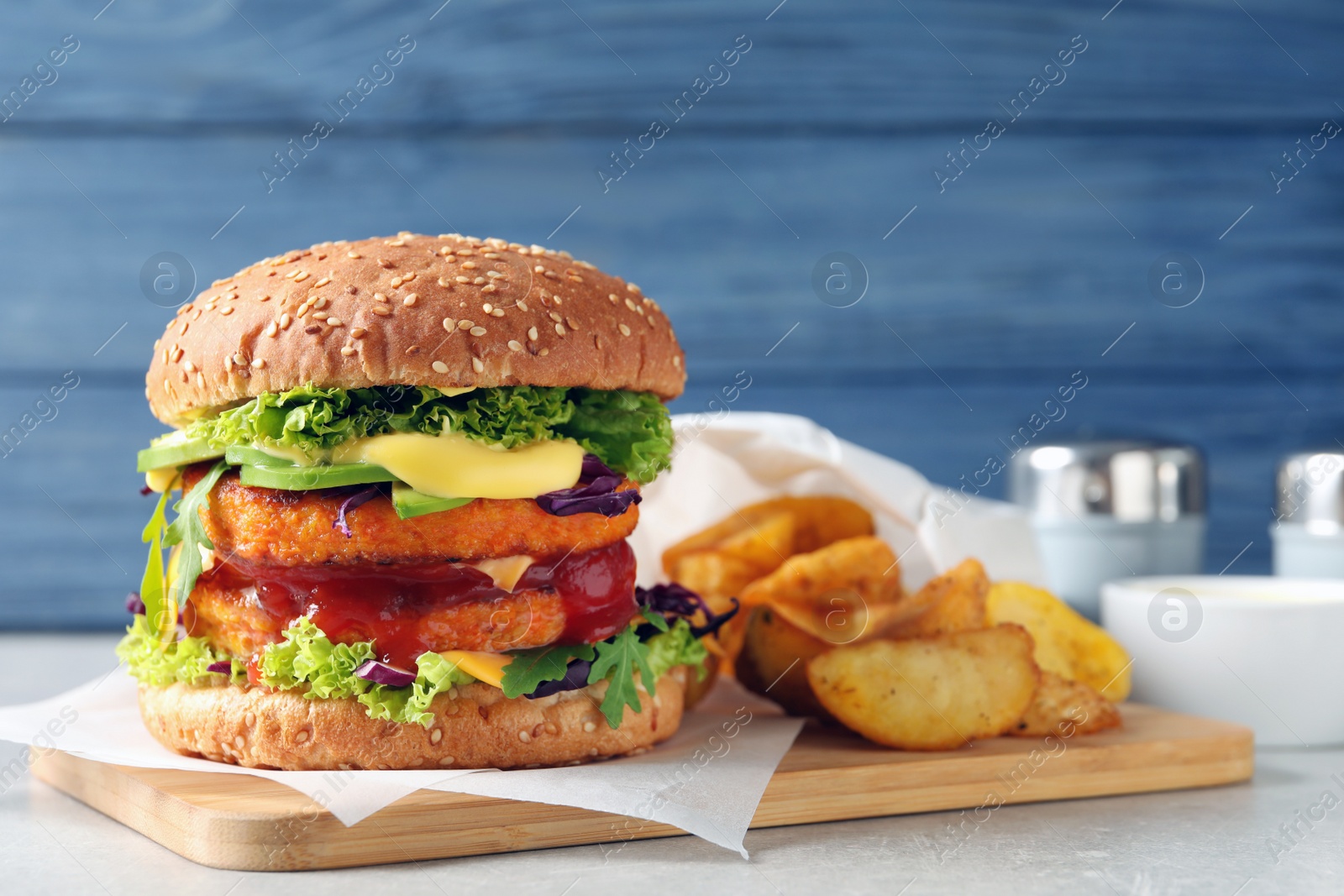 Photo of Vegan burger with carrot patties and fried potato served on table. Space for text