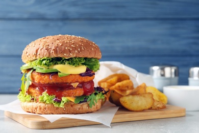 Vegan burger with carrot patties and fried potato served on table. Space for text