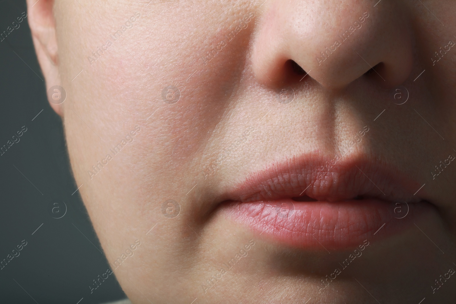 Photo of Closeup view of woman with healthy skin on grey background