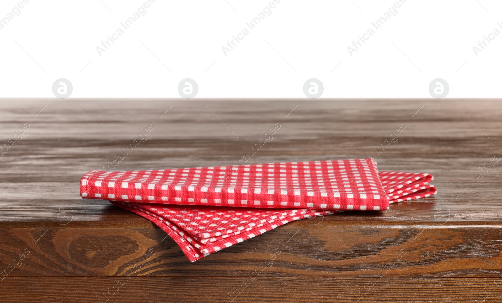 Photo of Checkered tablecloth on wooden table against white background