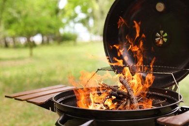 Photo of Modern barbecue grill with fire flames outdoors