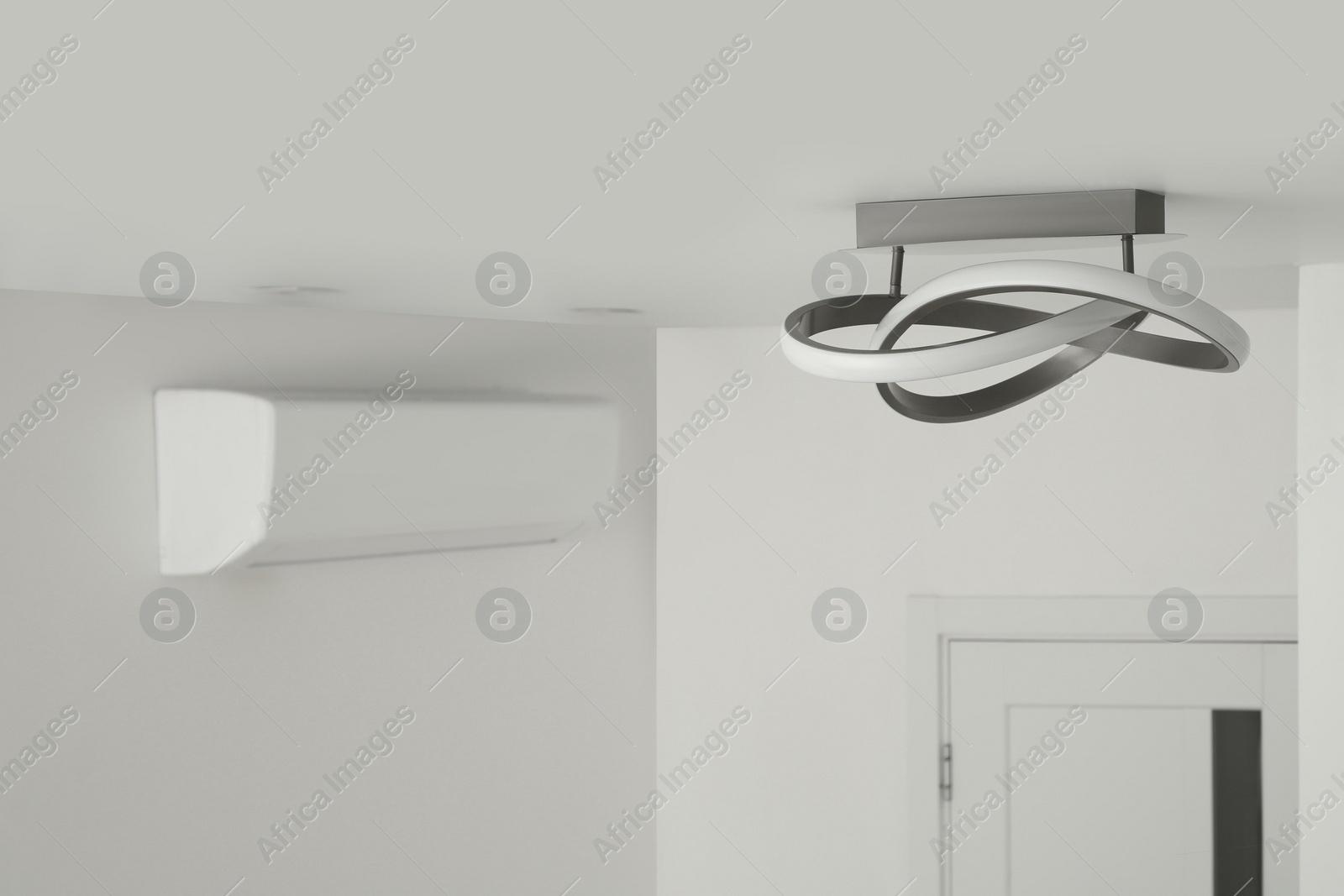 Photo of Stylish lamp on white ceiling. Space for text