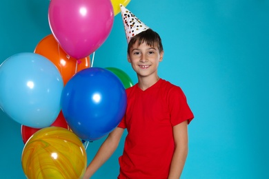 Happy boy with balloons on blue background. Birthday celebration