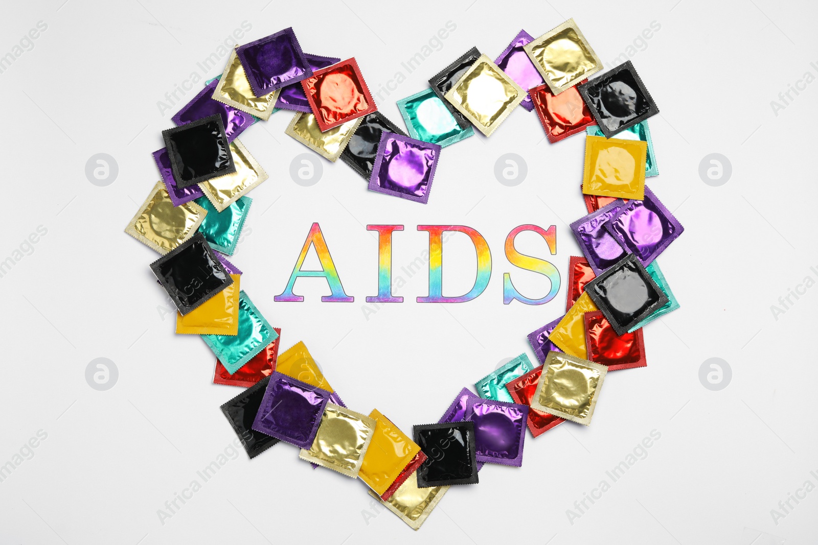 Photo of Frame made of colorful condoms with word AIDS inside on white background, top view. Safe sex