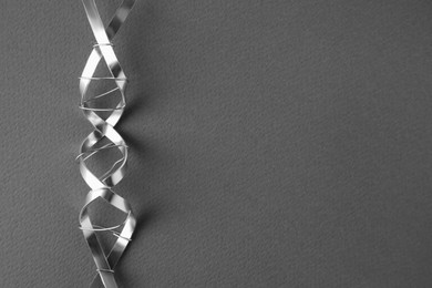 DNA molecular chain model made of metal on grey background, top view. Space for text