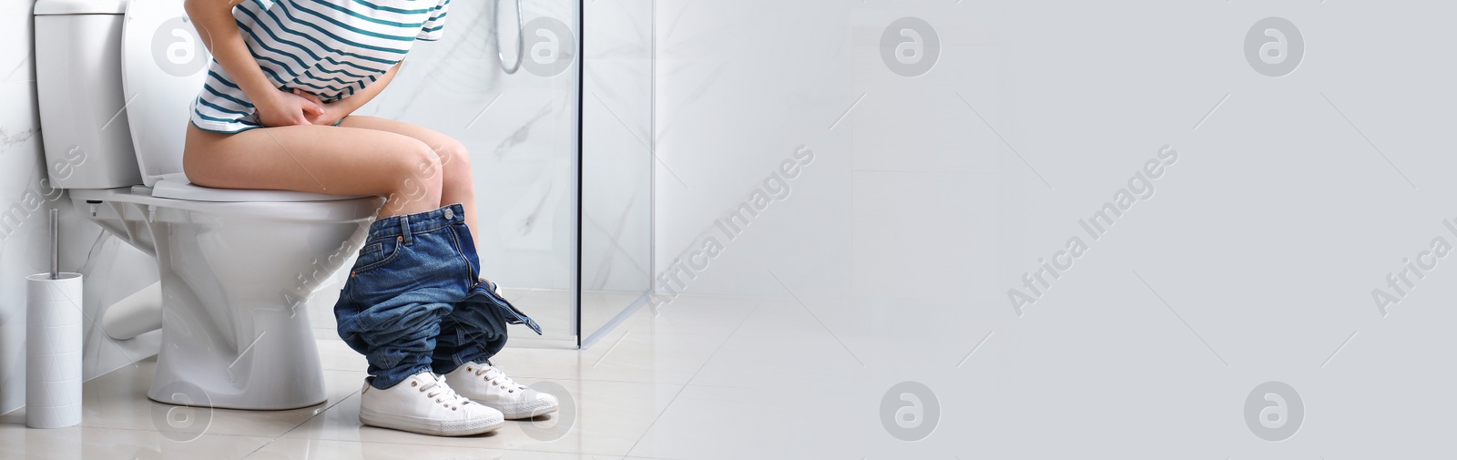 Image of Closeup view of woman with stomach ache sitting on toilet bowl in bathroom, space for text. Banner design