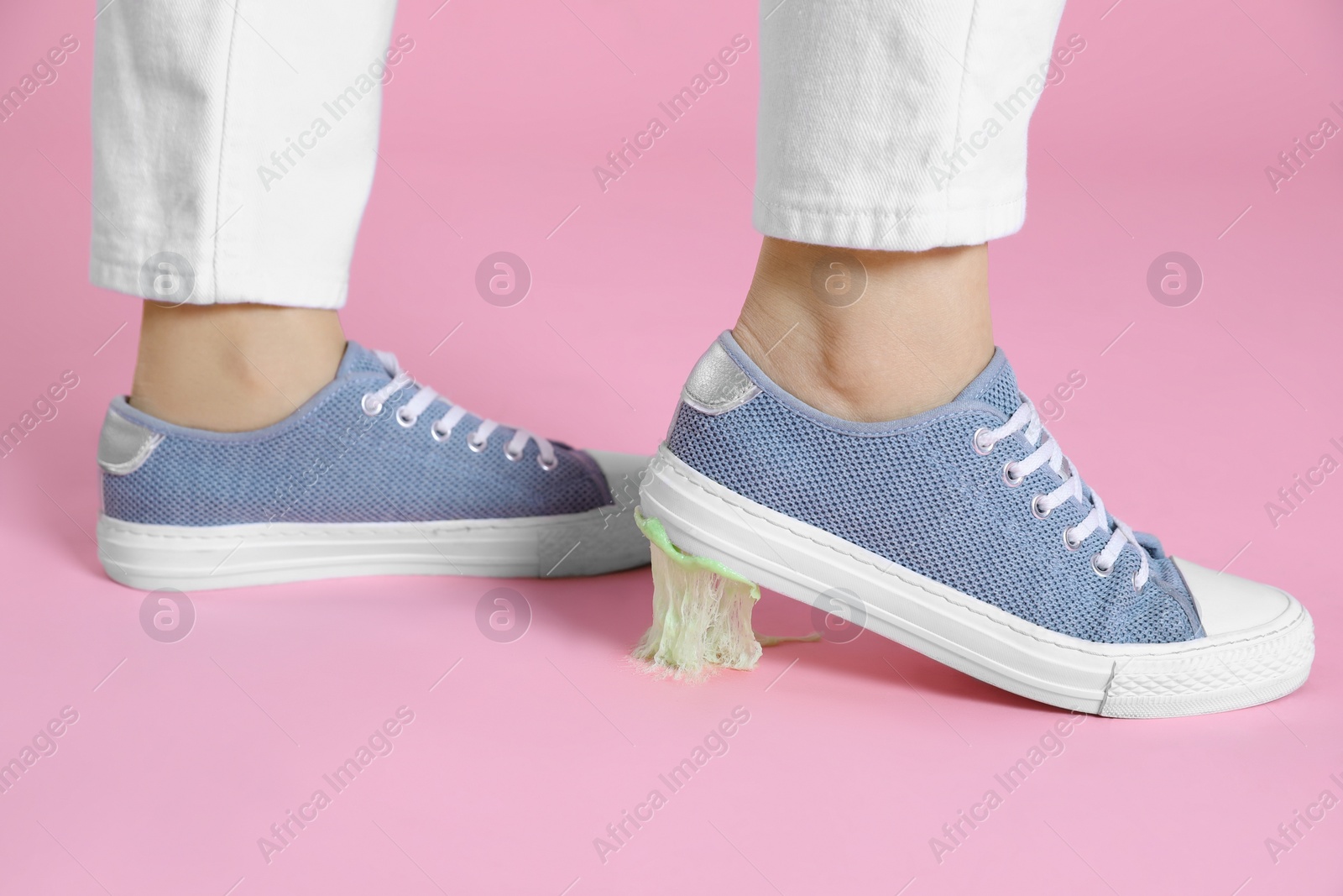 Photo of Person stepping into chewing gum on pink background, closeup