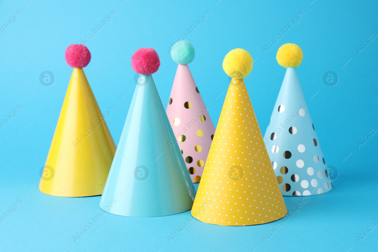 Photo of Colorful party hats on light blue background