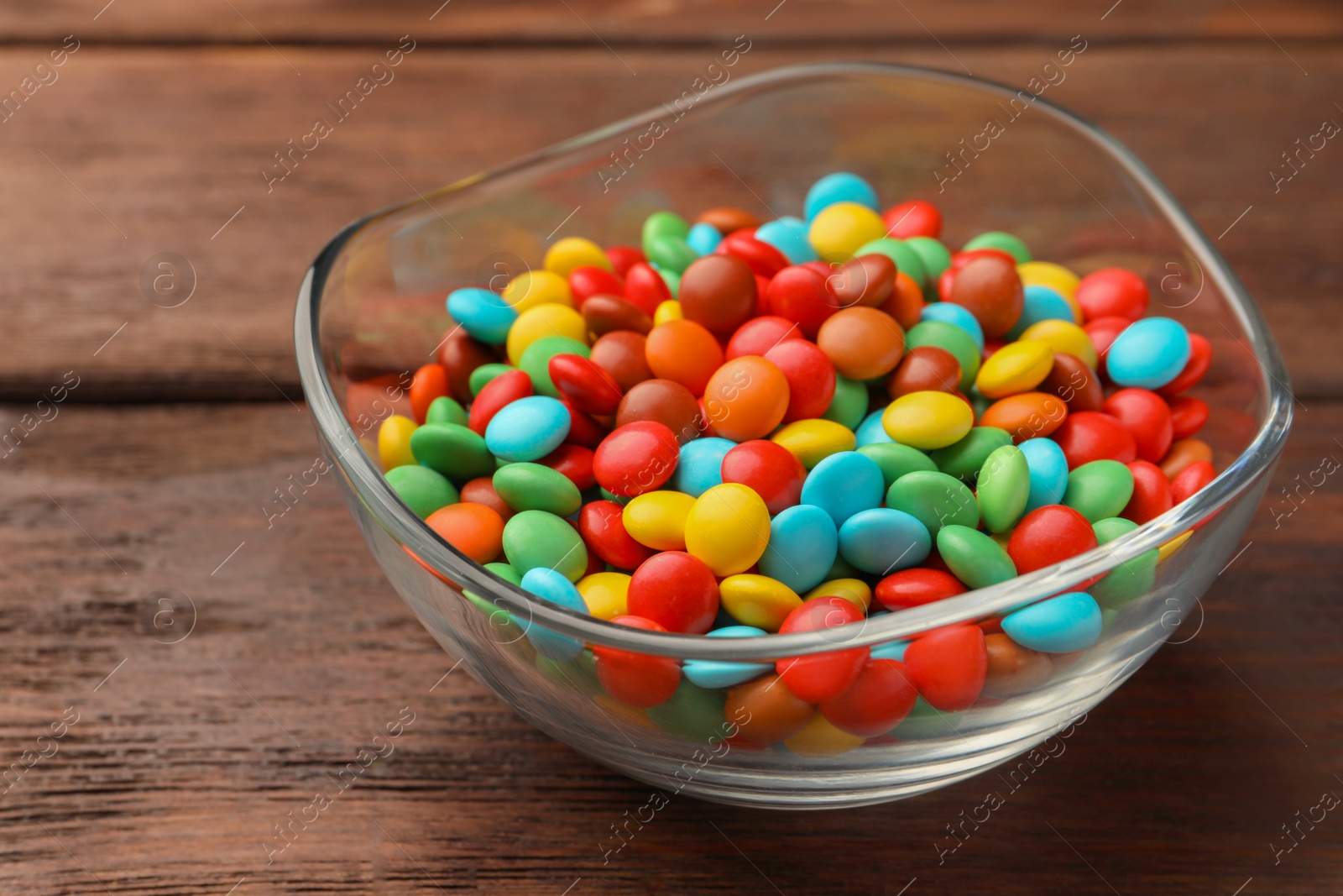 Photo of Tasty colorful candies on wooden table, closeup