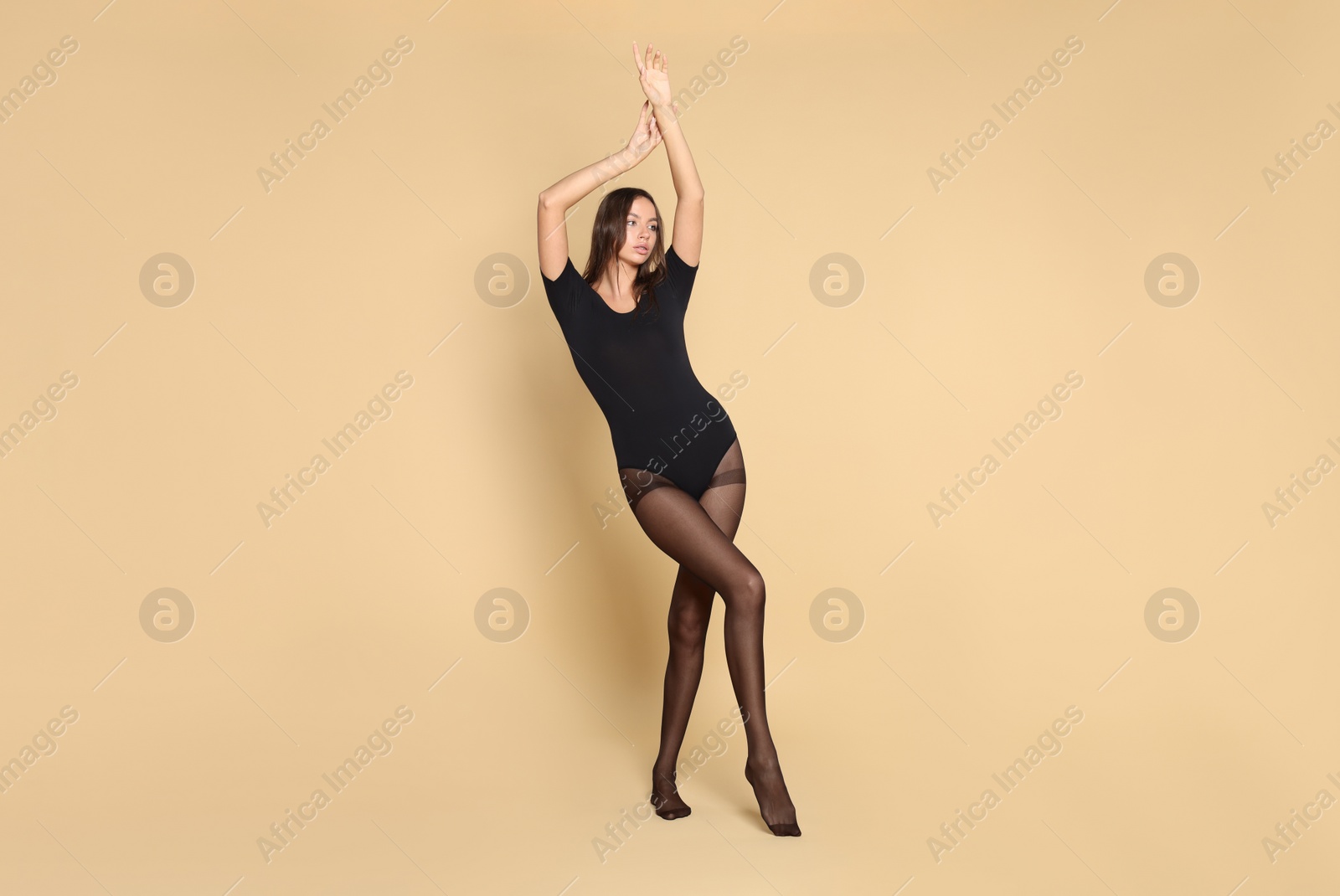 Photo of Beautiful woman wearing black tights on beige background