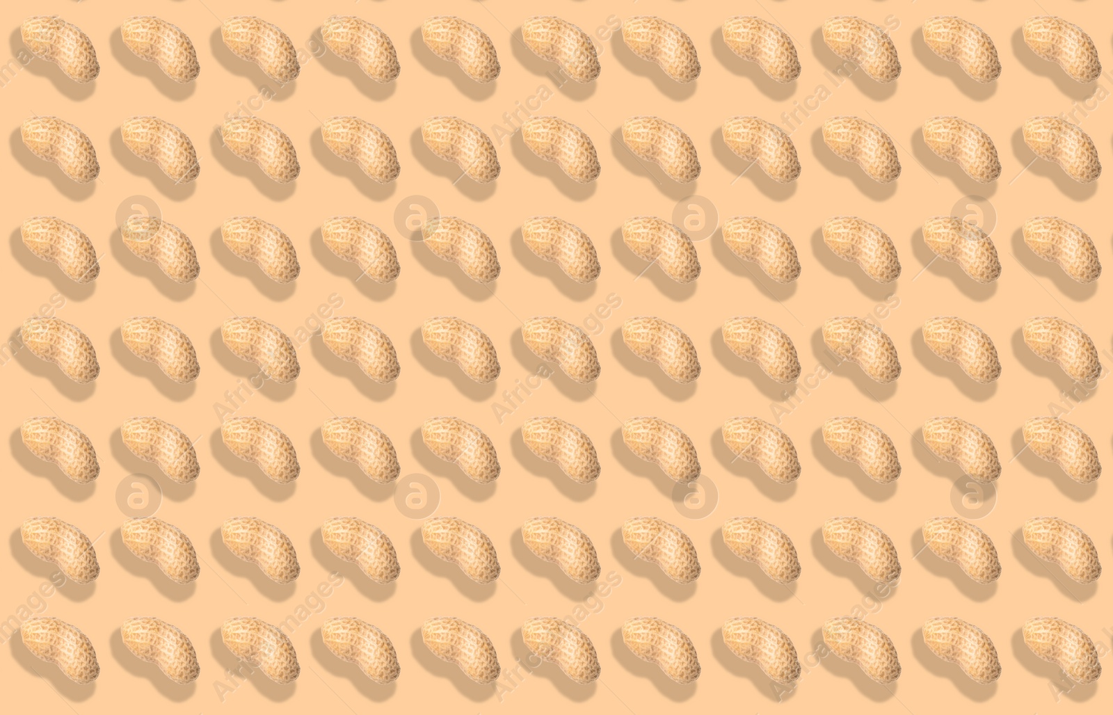 Image of Pattern of unpeeled peanuts on beige background