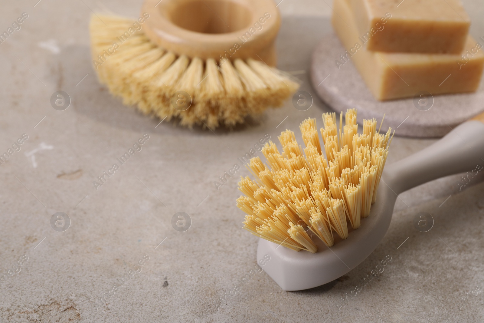 Photo of Cleaning brushes and soap bars on light grey table, space for text