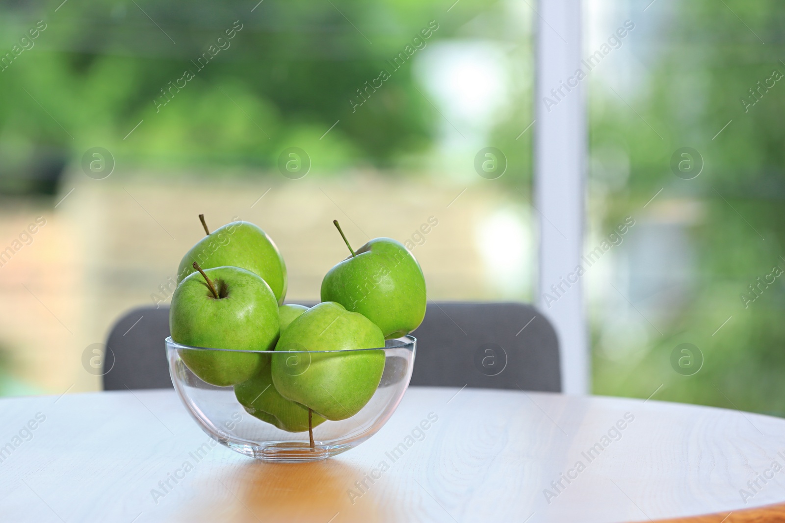 Photo of Bowl of fresh green apples on table indoors. Space for text