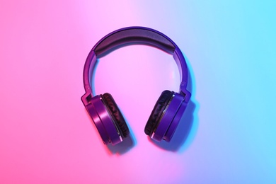 Stylish headphones on color background, top view