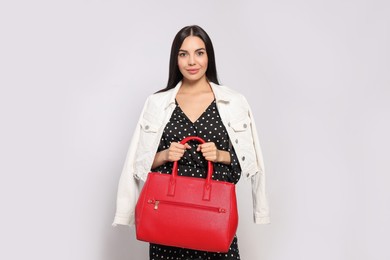 Photo of Young woman with stylish bag on white background,