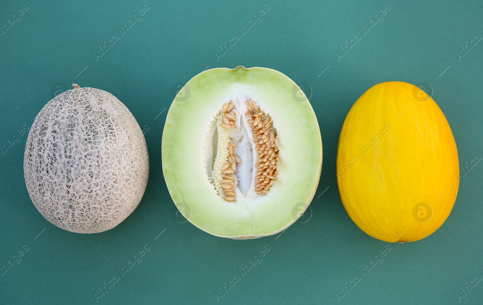 Photo of Different tasty ripe melons on teal background, flat lay