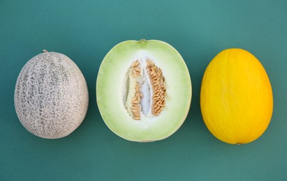 Different tasty ripe melons on teal background, flat lay