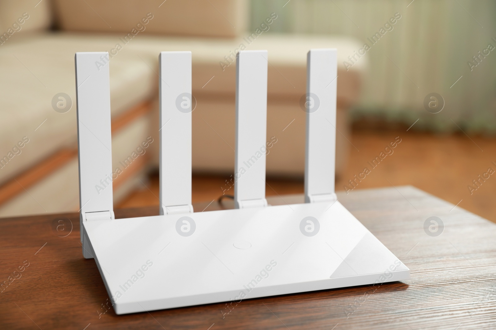 Photo of New modern Wi-Fi router on wooden table indoors