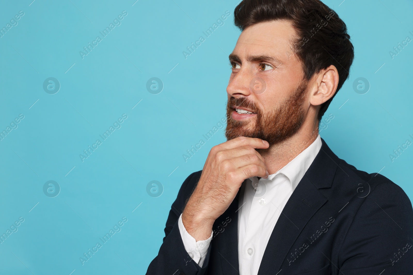 Photo of Portrait of handsome bearded man in suit on light blue background. Space for text