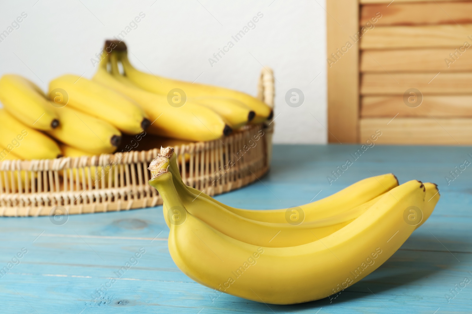 Photo of Ripe yellow bananas on light blue wooden table