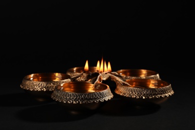 Photo of Diwali diyas or clay lamps on dark background