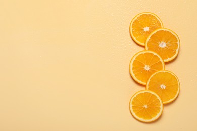 Photo of Slices of juicy orange and water on beige background, flat lay. Space for text