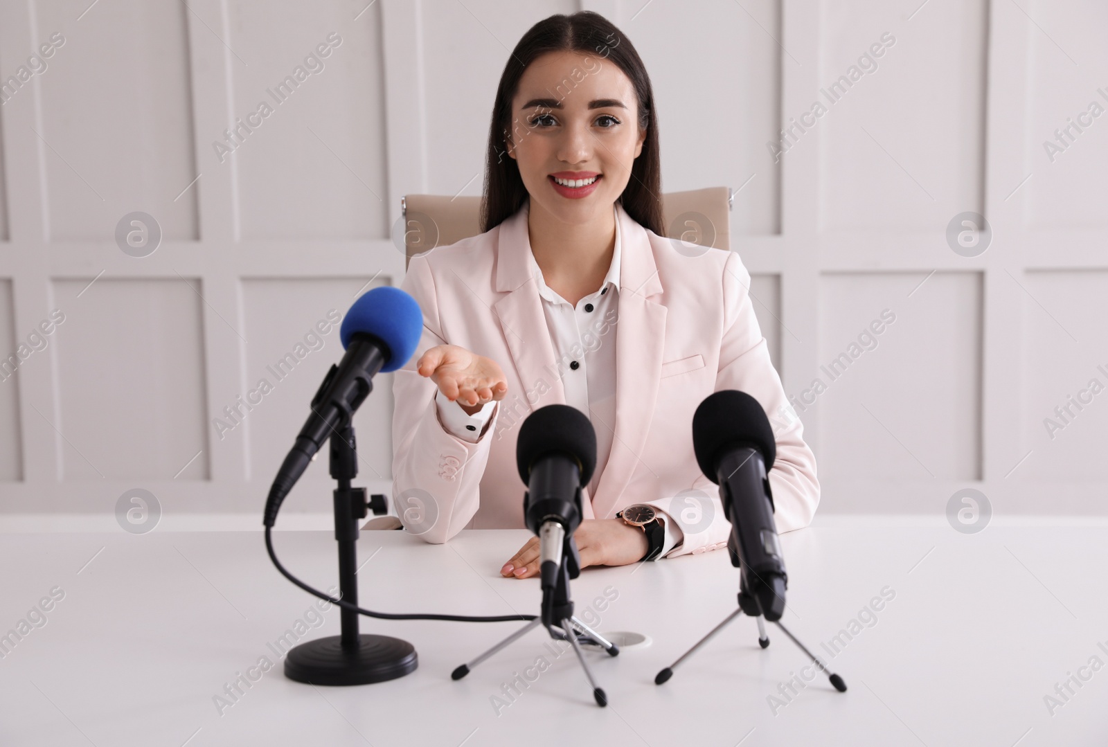 Photo of Happy young woman giving interview at official event