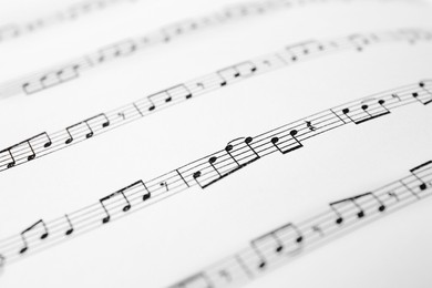 Photo of Sheet of paper with music notes as background, closeup
