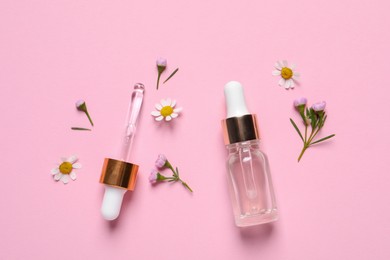 Photo of Bottle of cosmetic serum, pipette and beautiful flowers on pink background, flat lay