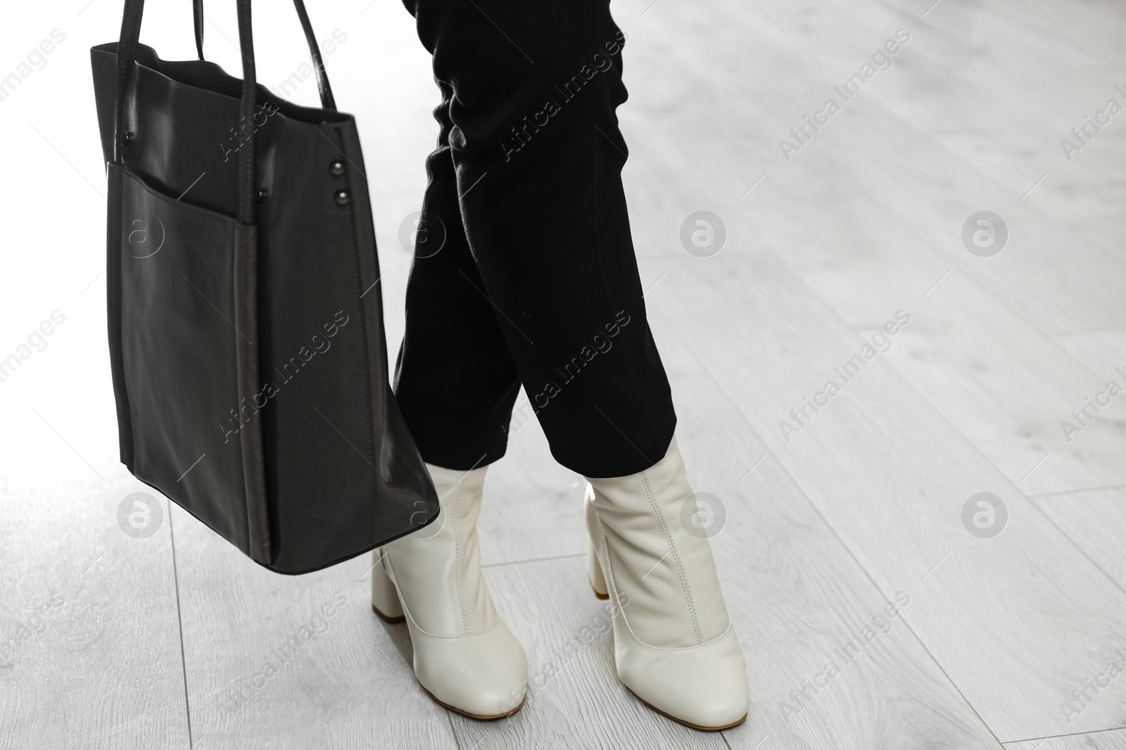 Photo of Woman wearing stylish leather shoes with bag indoors, closeup. Space for text