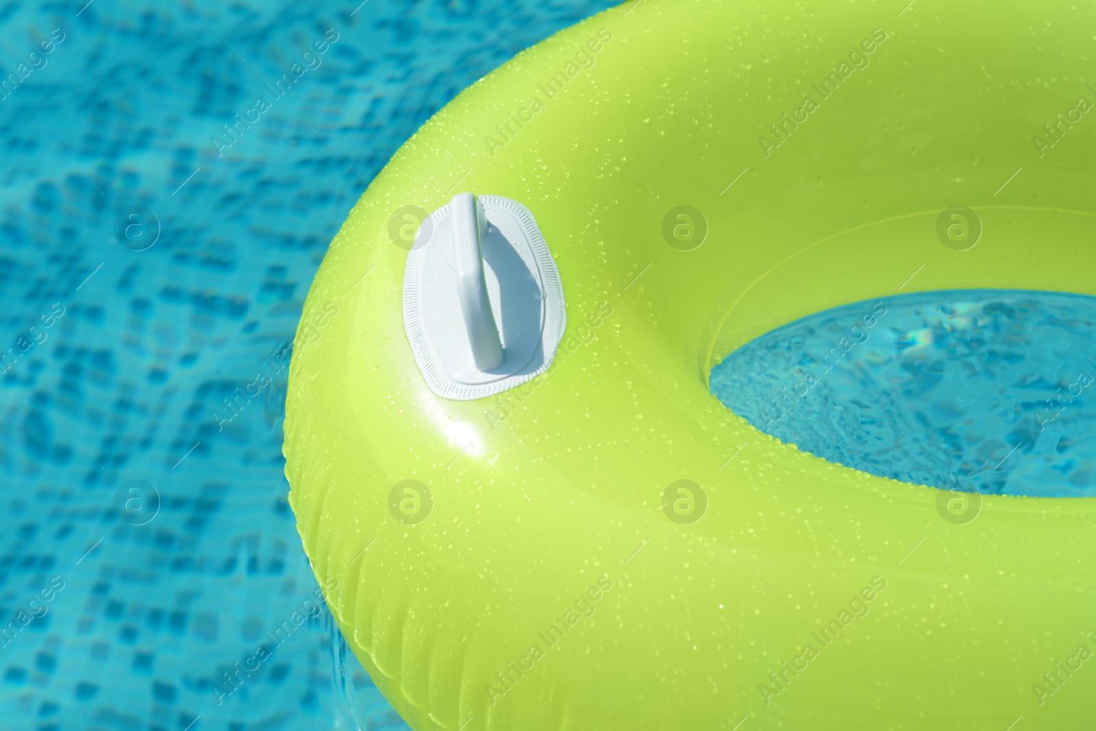 Photo of Light green inflatable ring floating in swimming pool, closeup