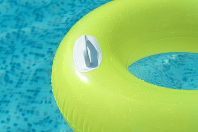 Photo of Light green inflatable ring floating in swimming pool, closeup